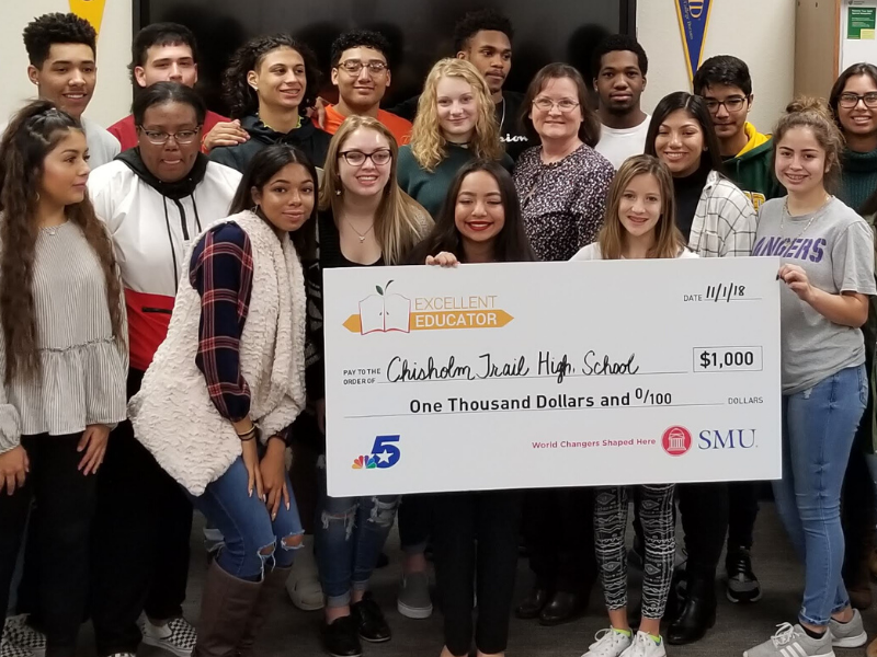 Students pose for a photo with a large photo